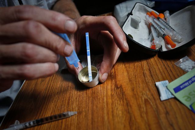 A heroin user places a fentanyl test strip in a mixing container to check for contamination.